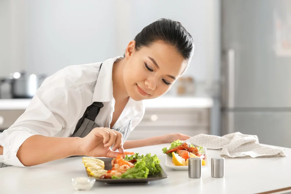 woman fixing the plating of a dish