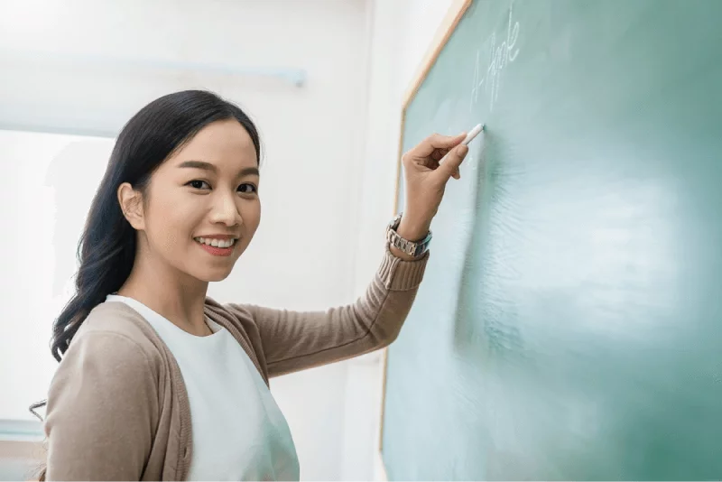 teacher writing something on the blackboard