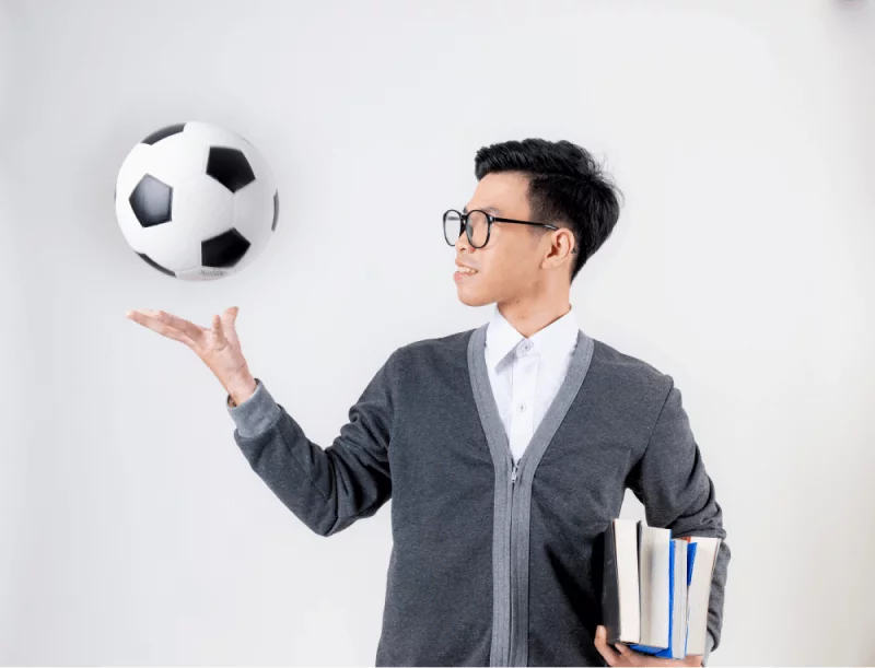 male student tossing a soccer ball