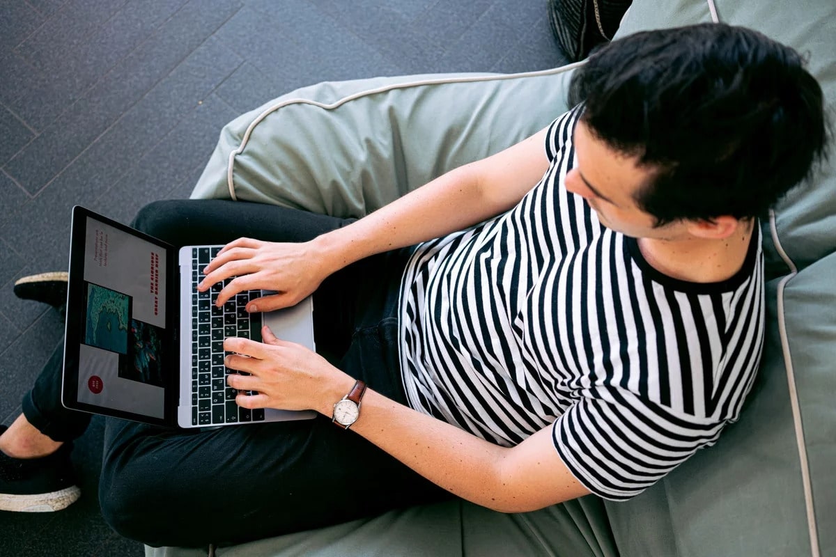 male student typing on a laptop