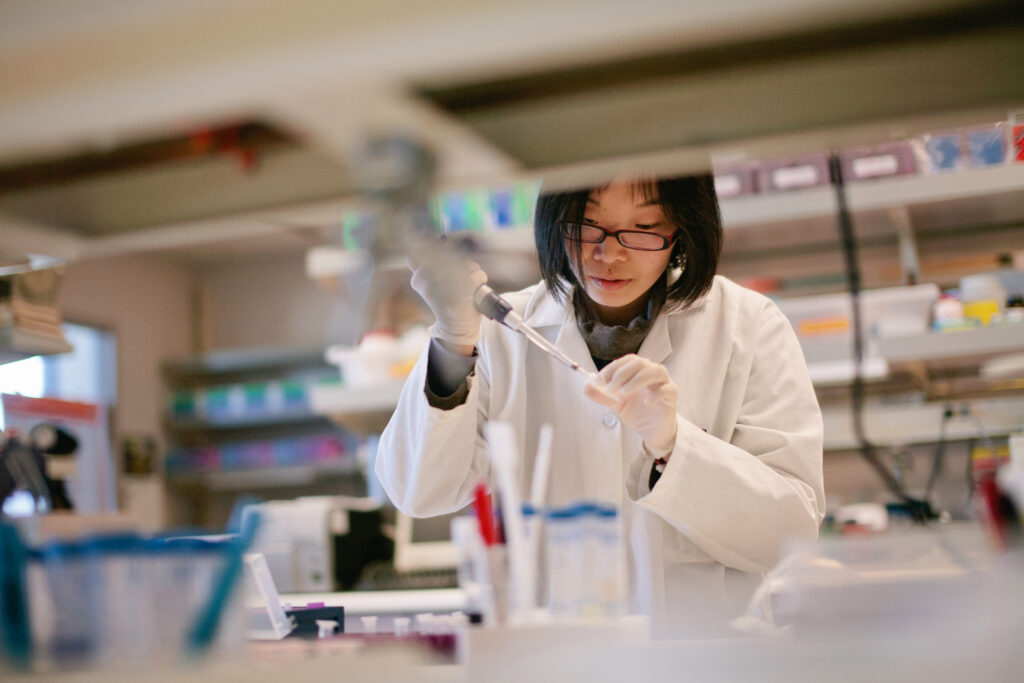 a scientist pipetting at a biomedical laboratory