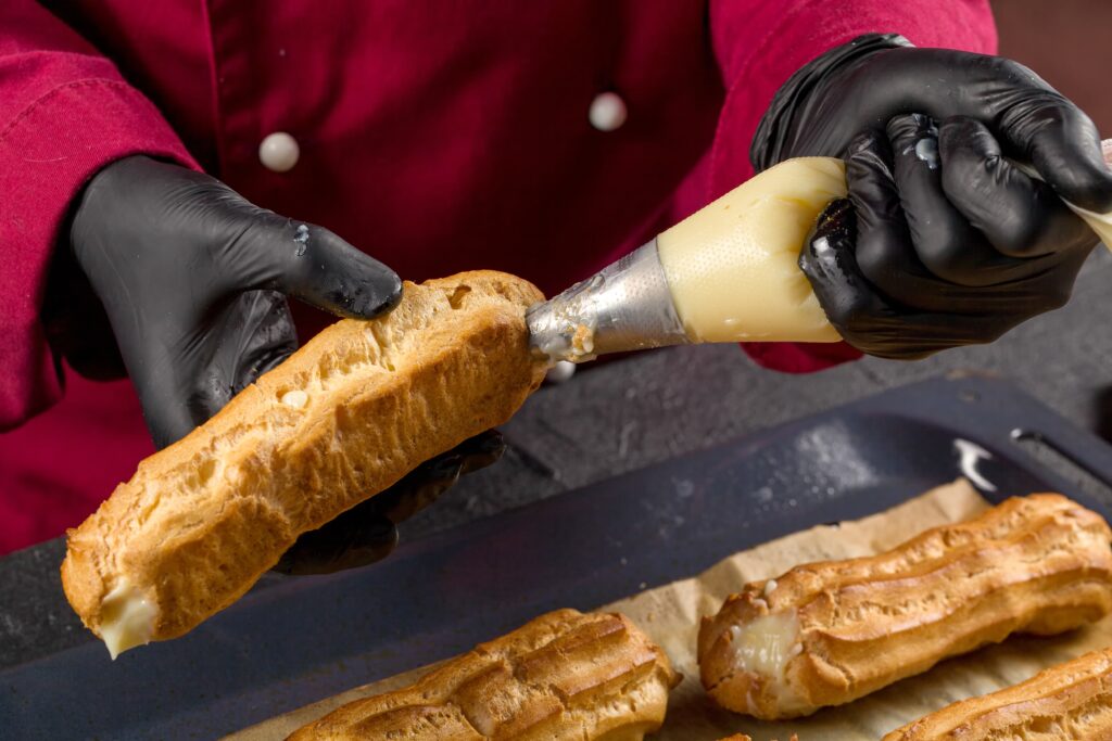 a pastry chef putting fillings on a pastry