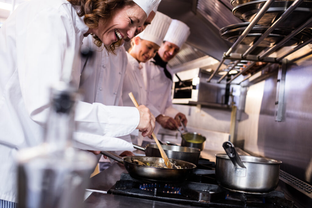 head chef teaching junior chefs in the kitchen